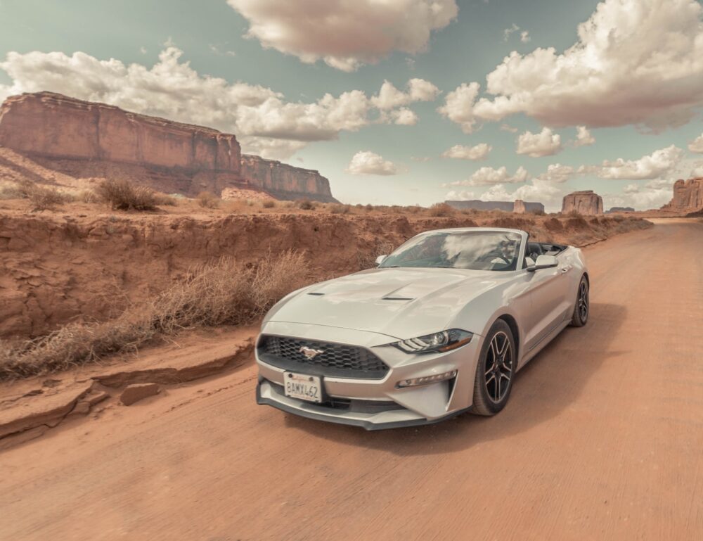 A silver car on a desert road