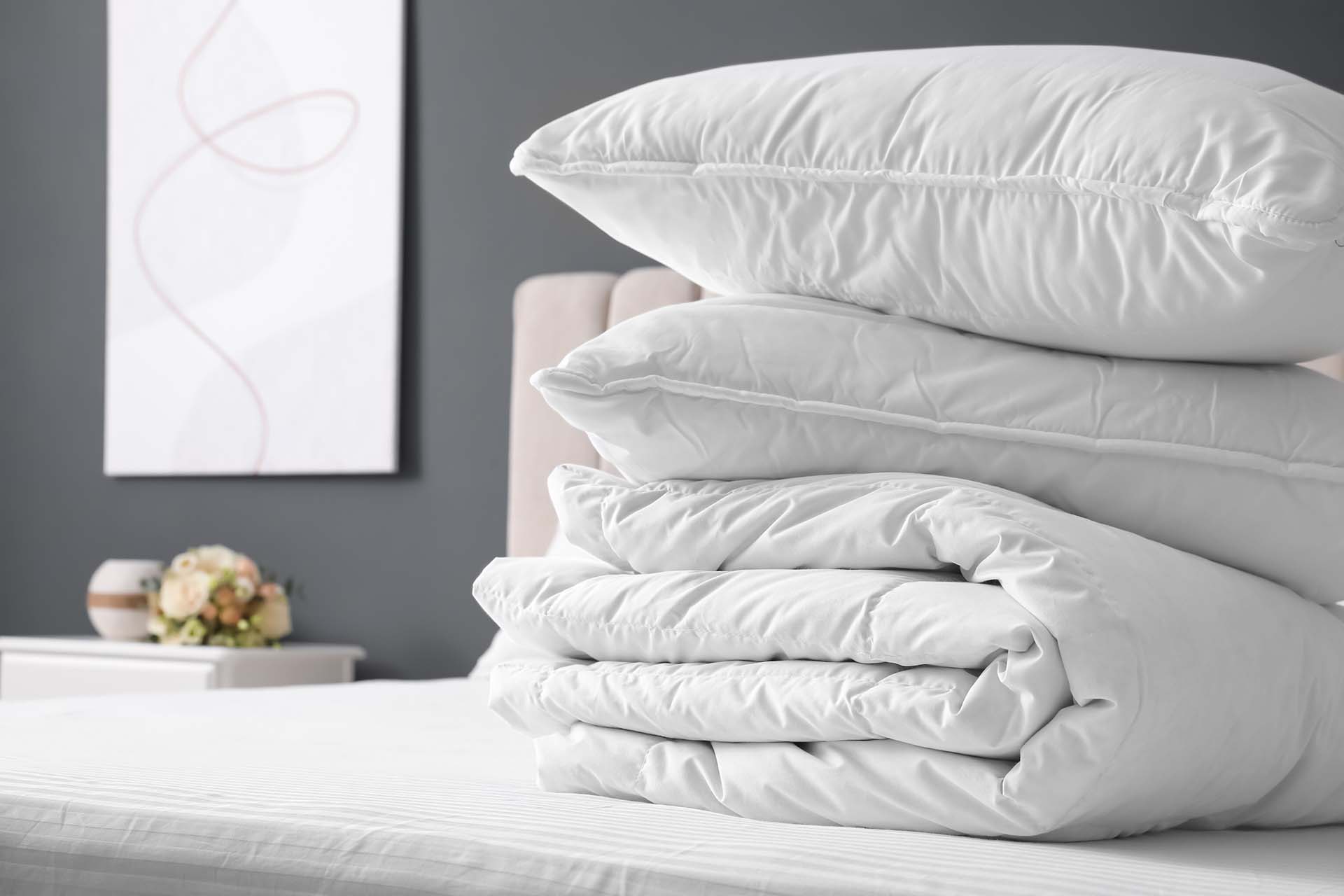 https://www.flatpriceautotransport.com/wp-content/uploads/2019/05/Soft-folded-blanket-and-pillows-on-bed-indoors-closeup.jpg