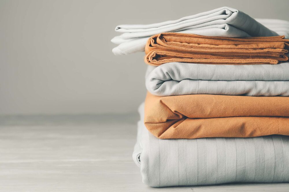 Stack of clean bed sheets on table