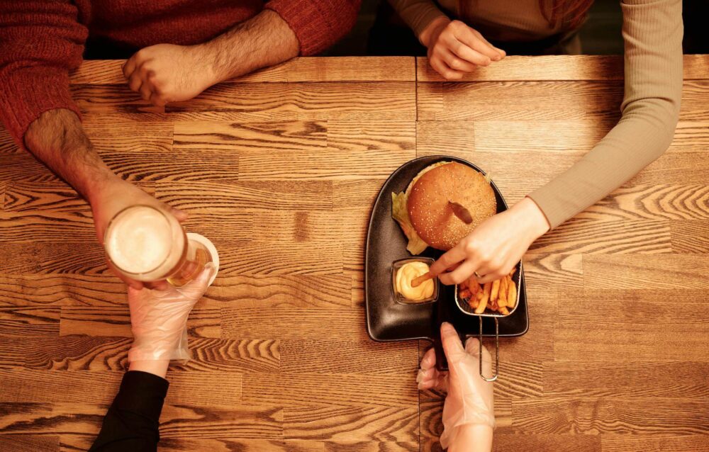 People eating burgers with beer