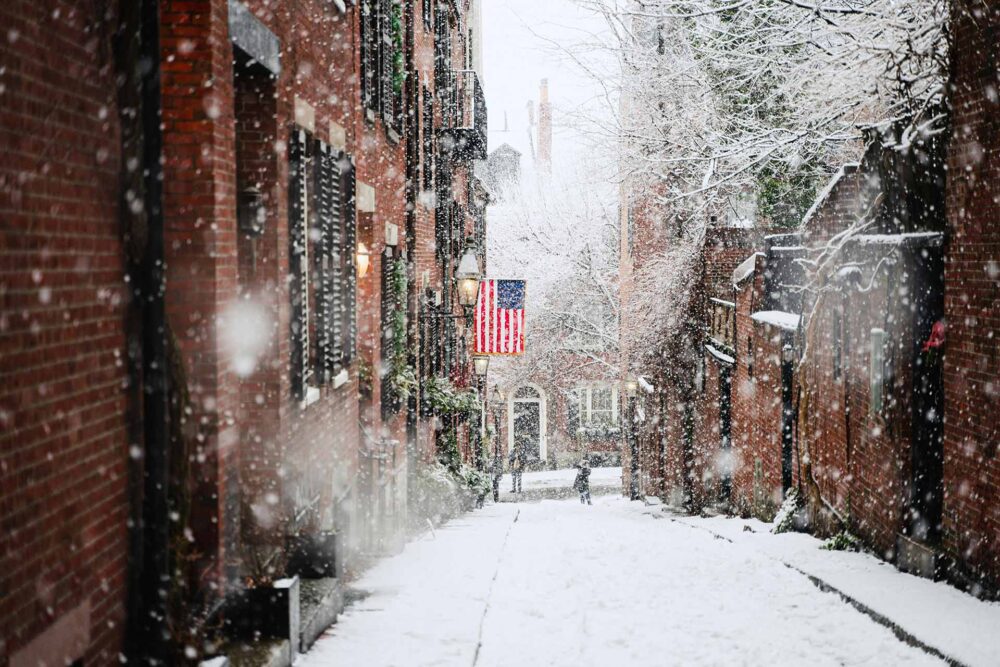 Boston, Beacon Hill snow covered road between brown concrete buildings