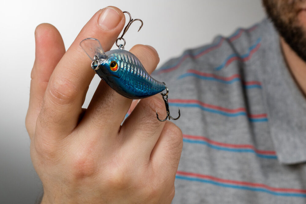 A man holding a fishing lure on his finger